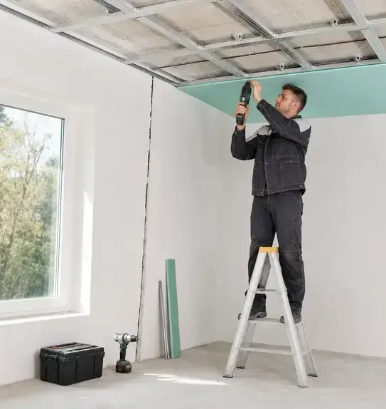 Worker installing a new drywall ceiling panel during ceiling water damage repair in Bay Village, OH